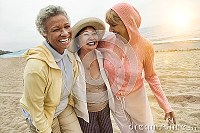Portrait of happy multi ethnic middle aged female friends enjoying vacation at beach Stock Photo
