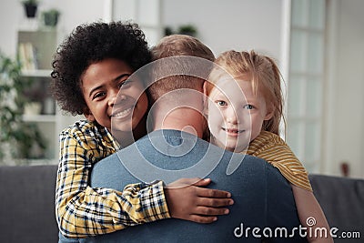 Happy adoptive children embracing father Stock Photo