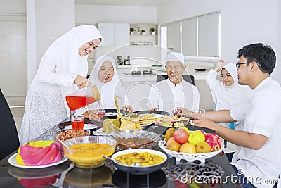 Happy muslim family eating together in dining room Stock Photo