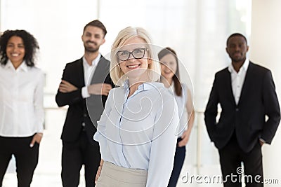 Portrait of happy older woman company ceo with diverse team Stock Photo