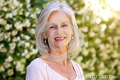 Portrait of happy older woman standing outside in summer Stock Photo