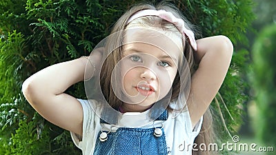 Portrait of happy pretty child girl standing in summer park looking in camera Stock Photo