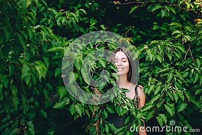 Portrait of happy pretty young teen girl in green leaves smiling healthy natural Stock Photo