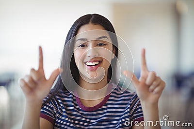 Portrait of happy schoolgirl gesturing in classroom Stock Photo