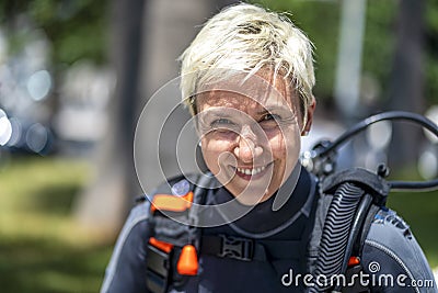 Portrait of a happy scuba diver with an oxygen tank and wet suit already on Stock Photo
