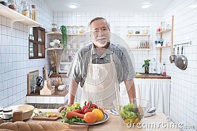 Portrait of happy senior elderly asian grandfather standing cooking meal in kitchen,Old men prepare dinner in hobby lifestyle Stock Photo