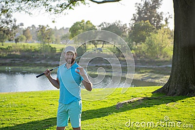 Portrait of happy smilin golfer hitting golf shot with club on course. Stock Photo