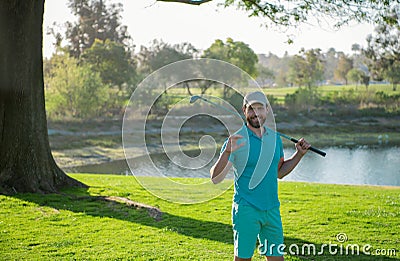 Portrait of happy smilin golfer hitting golf shot with club on course. Stock Photo