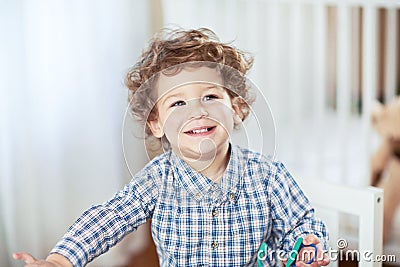 Portrait of happy smiling beautiful little boy in babyroom - checked shirt Stock Photo