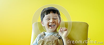 Portrait of happy smiling child boy isolated on yellow background. Portrait of happy joyful laughing beautiful little boy on Stock Photo