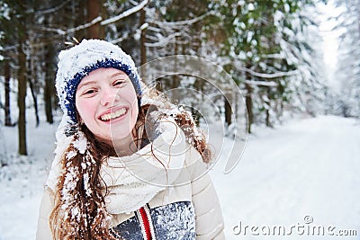 Portrait of happy smiling girl in winter snowy forest Stock Photo