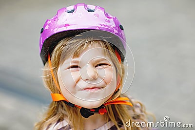 Portrait of happy smiling preschool girl with bycicle helmet on head. Cute toddler child. Safe bike driving with Stock Photo