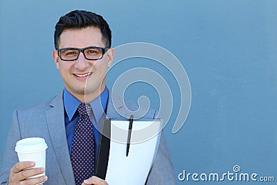 Portrait of happy smiling young business man with a suit, tie and classic glasses against blue background Stock Photo