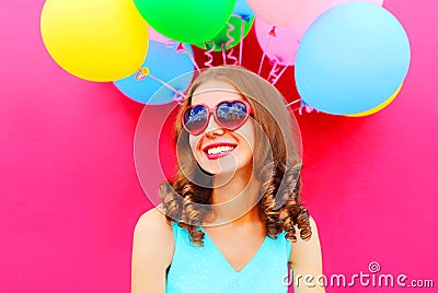 Portrait happy smiling young woman having fun over an air colorful balloons pink Stock Photo