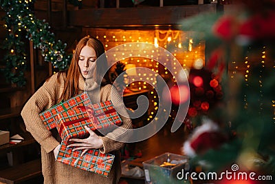 Portrait of happy surprised woman dropping gift boxes with Christmas presents wrapped in craft paper Stock Photo