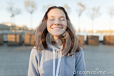 Portrait of a happy teen girl with eyes closed, golden hour Stock Photo