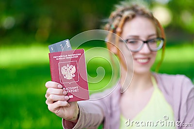 Portrait of happy tourist woman with dreadlocks holding passport and coffee on holiday Stock Photo