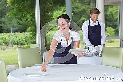 Portrait happy waiter and waitress standing in restaurant Stock Photo
