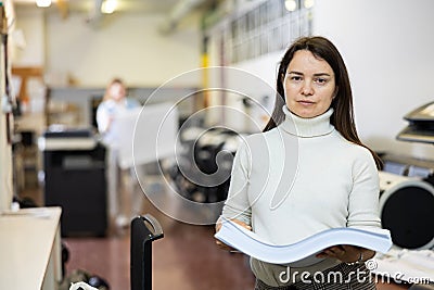 Portrait of happy woman with a stack of paper in her hands in typography Stock Photo