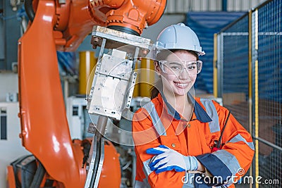 portrait happy woman worker with robot assembly machine in modern metal industry factory Stock Photo