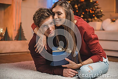 portrait of happy woman with wrapped gift hugging boyfriend Stock Photo