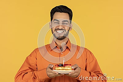 Portrait Of Happy Young Arab Man Holding Piece Of Cake With Candle Stock Photo