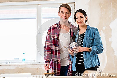 Portrait of a happy young couple holding tools for home remodeling Stock Photo