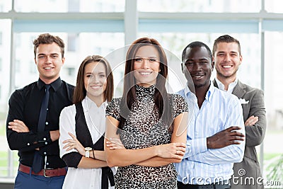 Portrait of a happy young female business leader standing in front of her team. Stock Photo
