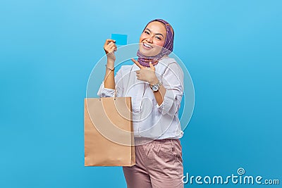 Portrait of happy young girl holding shopping bag and credit card Stock Photo