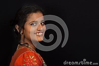 Portrait of a happy young Indian girl smiling on black background. Stock Photo