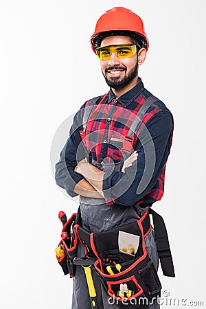 Portrait of happy young indian male construction worker with tool belt isolated on white background Stock Photo