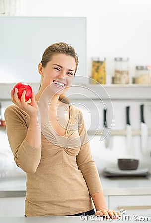 Portrait of happy young woman apple in kitchen Stock Photo