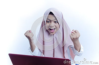 Portrait of happy young woman celebrating success with arms up and shout out in front of laptop Stock Photo