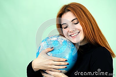 Portrait of a happy young woman holding geographic globe of the world in her hands. Travel destination and planet protection Stock Photo