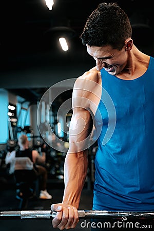 Portrait of healthy fitness man working out at gym. Athlete and professional certified trainer training with weights at gym Stock Photo
