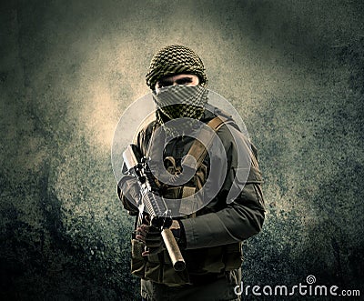 Portrait of a heavily armed masked soldier with grungy background Stock Photo