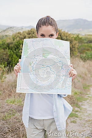 Portrait of a hiking young woman holding map Stock Photo