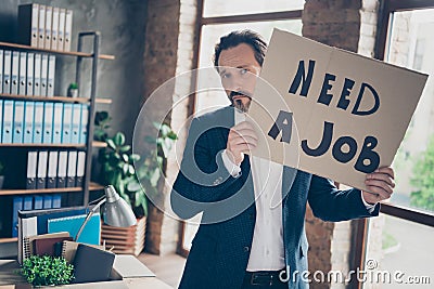 Portrait of his he depressed jobless guy qualified expert employer wearing jacket holding in hands placard saying need a Stock Photo