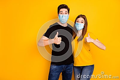 Portrait of his he her she nice attractive healthy couple showing thumbup wearing safety mask stop pandemia mers cov Stock Photo