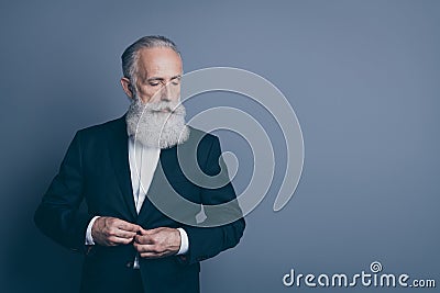 Portrait of his he nice attractive chic classy serious content minded gray-haired man macho wearing tux fastening button Stock Photo