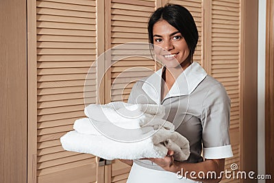 Portrait of a hotel maid holding fresh clean folded towels Stock Photo