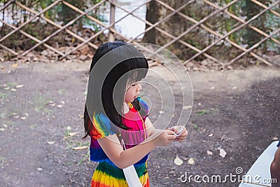 Portrait image Asian child 4 years old. Cute kid are playing raffle activities. Children sweat on face due to hot weather. Stock Photo