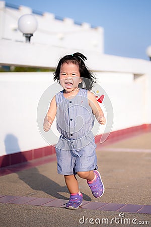 Portrait image baby age 2-3 years old. Asian Child girl don't like to be still running playing have fun. Sweet smile . Stock Photo