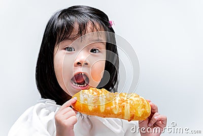 Portrait image. Child having fun eating sweets. Sweet bread is eaten as a snack. Stock Photo