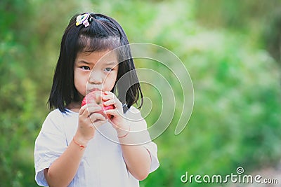 Portrait image child 4-5 years old. Asian little girl is about to eat an apple. Children do not like to eat fruit. Empty space. Stock Photo