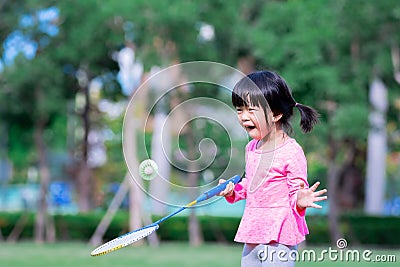 Portrait image child 5 years old. Cute Asian girl having fun playing badminton. Little children enjoy playing outdoor sports. Stock Photo