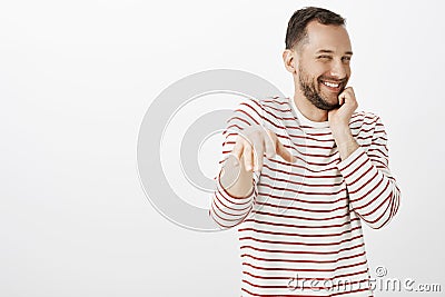 Portrait of impatient pleased cute gay boyfriend in striped shirt, blushing while man making proposal, chuckling from Stock Photo