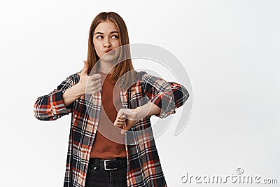 Portrait of indecisive girl shows dislike or like, thumbs up and thumbs down, looking aside thoughtful, thinking of Stock Photo