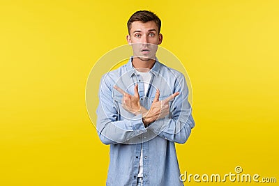 Portrait of indecisive male customer asking help with choice. Clueless guy pointing fingers sideways at left and right Stock Photo