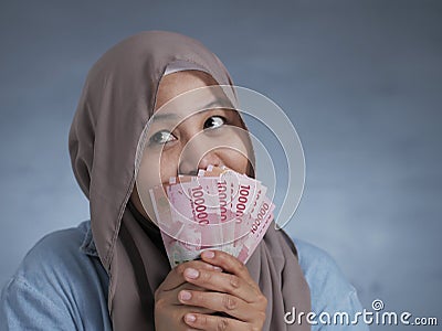 Indonesian Muslim Woman Holding Rupiah Money Stock Photo